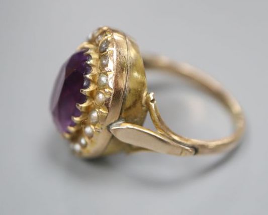 An early 20th century 9ct, amethyst and split pearl set oval dress ring, size N, gross 4.8 grams, (one pearl missing).